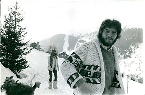 תצלום וינטג 'של בריג'יט ברדו עומד על שלג, אדם עומד מלפנים.